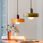 Oakhampton pendant lights in olive and orange above a dining table