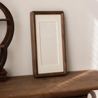 Gorlitz walnut tone frame standing on a wooden shelf