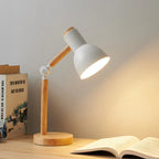 Elmsworth wooden desk lamp in white, lit over an open book