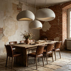 Three Rothwell cream pendants above a long table against exposed brick