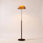 Aalen amber dome mushroom floor lamp switched on, on a light studio background