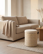 Natural Amrum storage stool beside a boucle sofa as an extra seat
