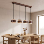 Bregenz four light bar pendant lit above a dining table