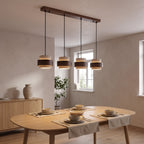 Bregenz four light bar pendant glowing over a set dining table in the evening