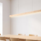 Hjo linear pendant lit over an oak table