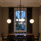 Eckernforde black chandelier lit over a walnut dining table in a Victorian dining room
