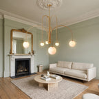 Eckernforde gold chandelier hanging from a ceiling rose in a sage green Georgian living room