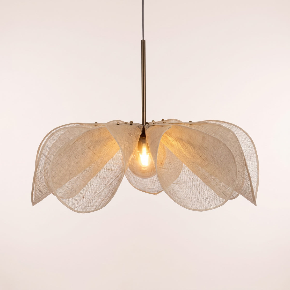 Fussen sheer fabric petal pendant light lit, on a light studio background