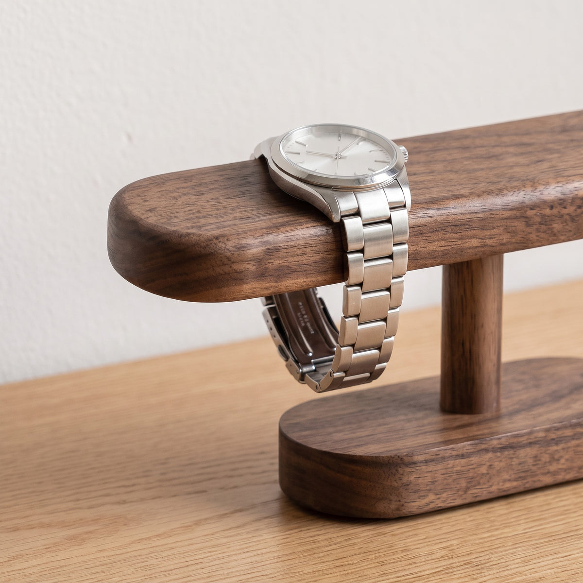 Close up of a watch resting on the walnut bar of the Hagen stand