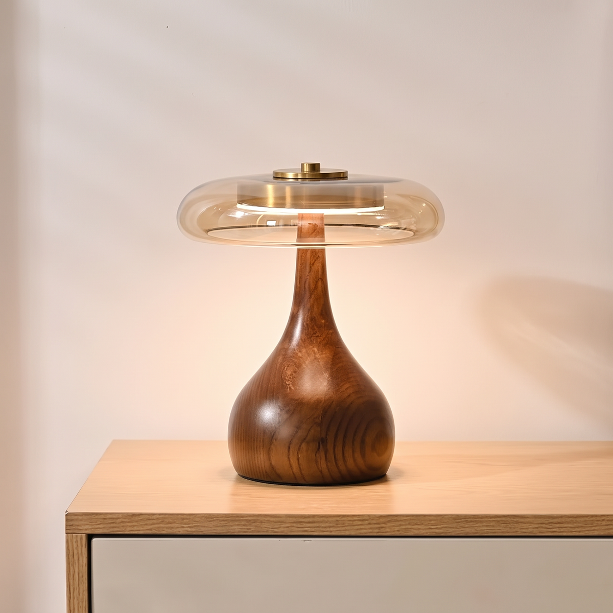 Amber glass table lamp glowing on a walnut console