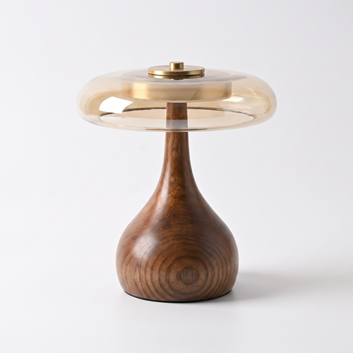 Amber glass and walnut table lamp on a white background