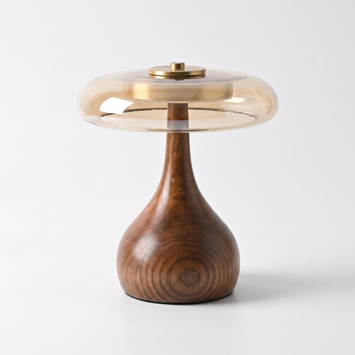 Amber glass and walnut table lamp on a white background