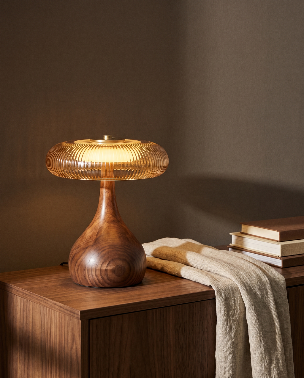 Thornbury amber glass table lamp lit on a walnut console at dusk