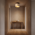 Wroxham travertine ceiling light lit in a narrow plaster hallway
