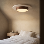Tilbury travertine and walnut ceiling light above a linen dressed bed