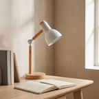 Elmsworth white and wood desk lamp on an oak study desk beside an open notebook