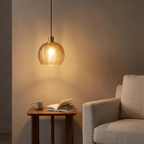 Quenby ribbed amber glass pendant light above a reading corner side table