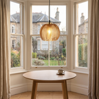 Quenby ribbed amber glass pendant light above a round oak table in a bay window