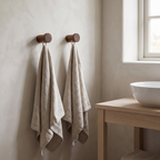Two Celle walnut peg hooks holding towels