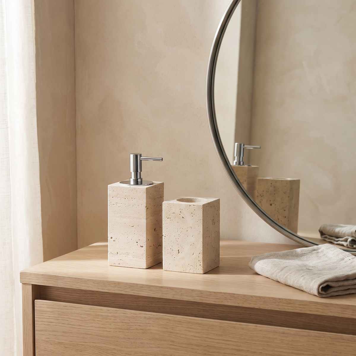 Malvern travertine soap dispenser and tumbler beside a basin