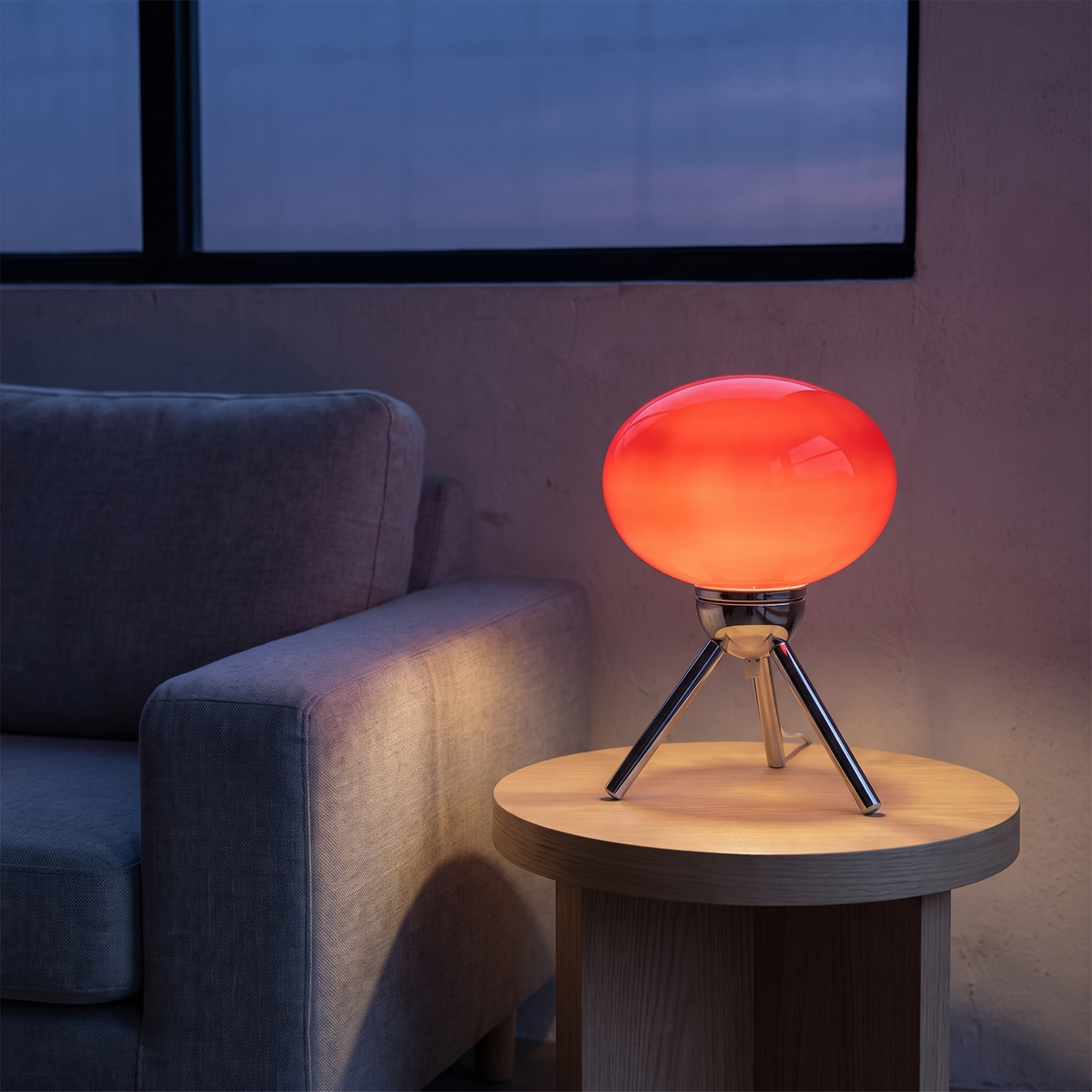 Jena lamp lit on a side table at dusk