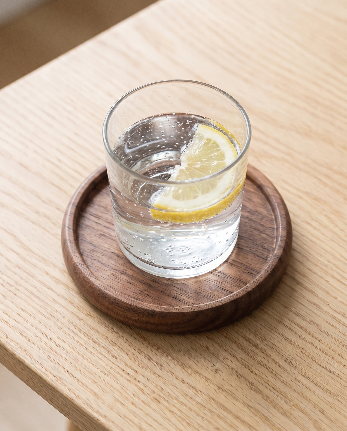 Aalborg walnut coaster with a glass of water