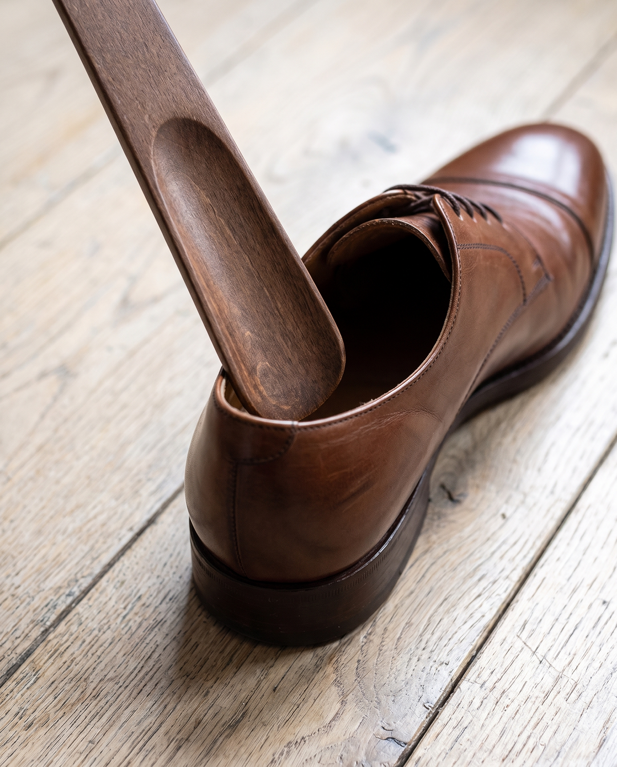 Herford shoe horn guiding a heel into a leather shoe