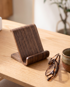 Hameln walnut finish phone stand beside reading glasses