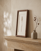 Gorlitz walnut tone frame with a botanical print on a stone mantelpiece