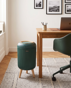 Dark green Naestved bin on legs beside a desk