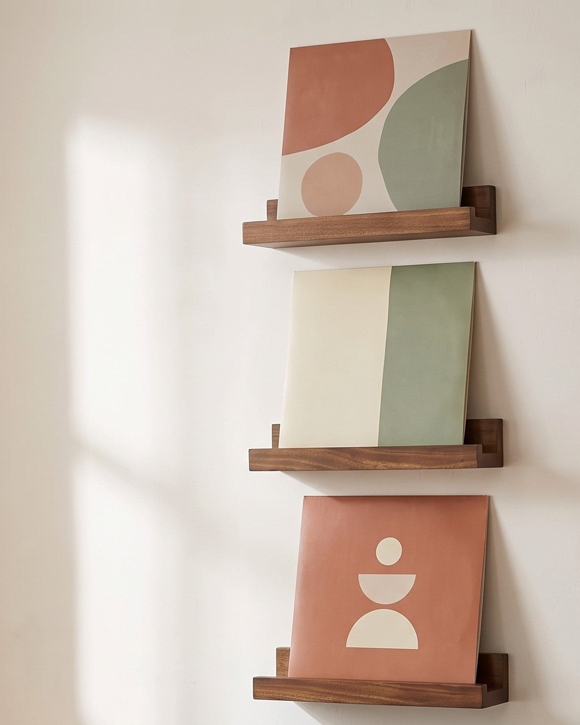 Three Husavik walnut tone record ledges stacked on a plaster wall