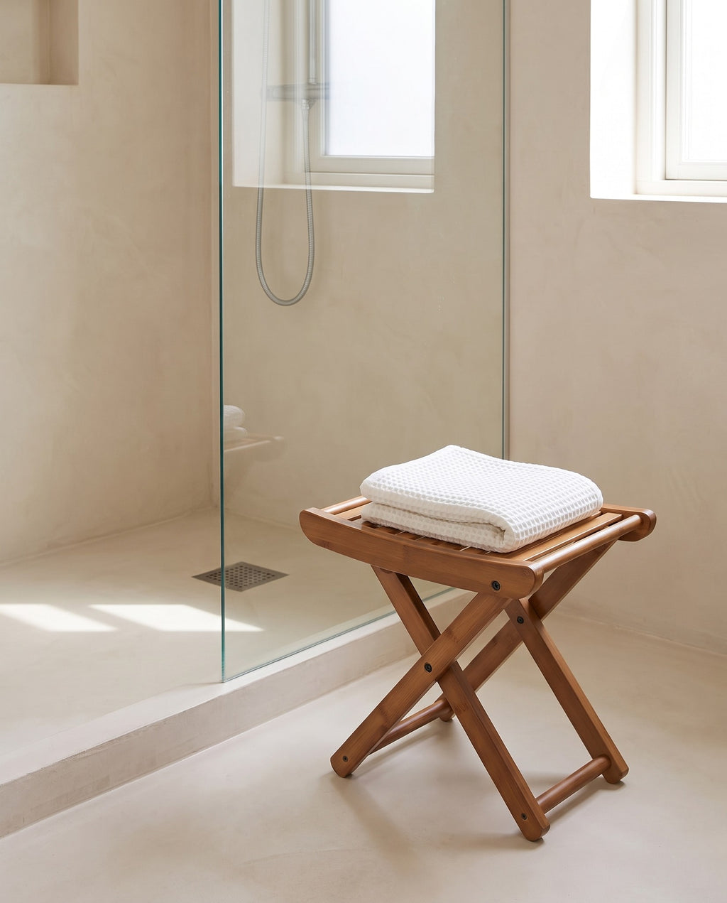 Interlaken bamboo stool beside a walk in shower with a towel