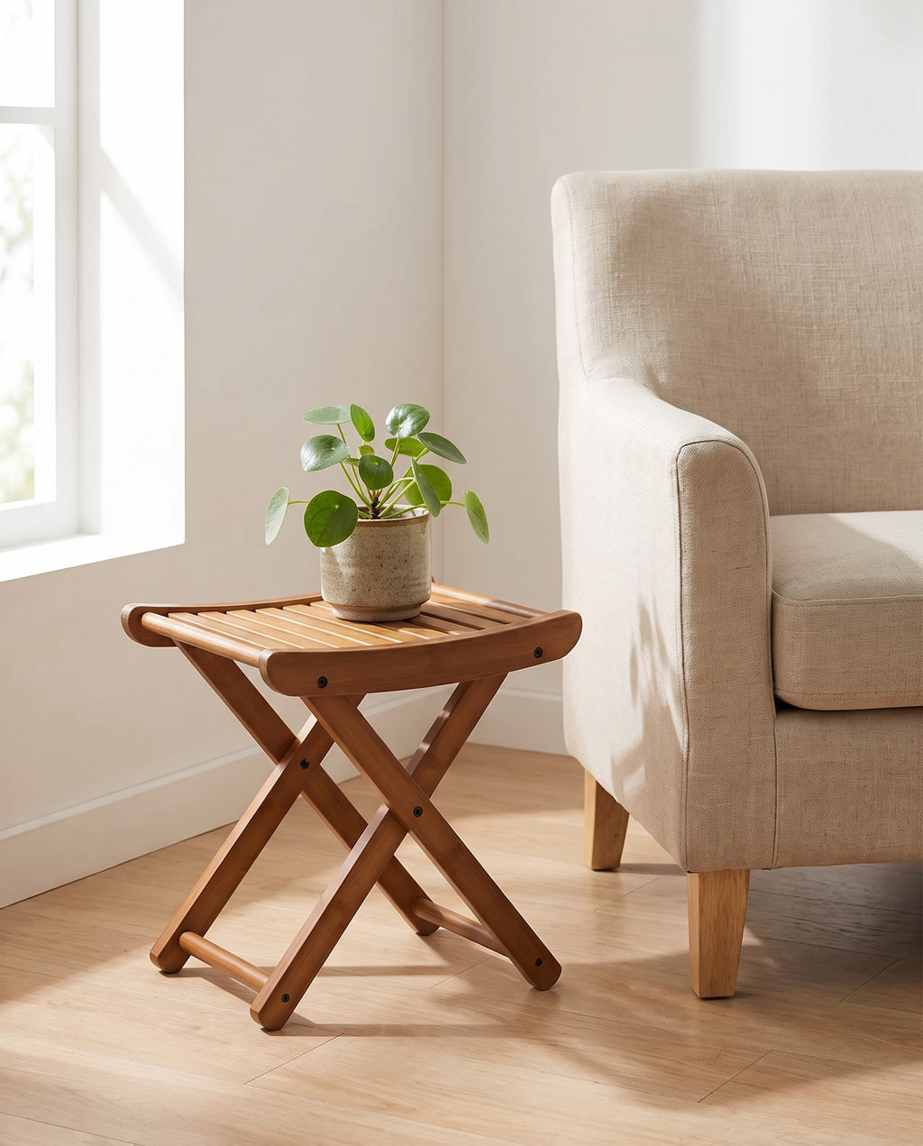 Interlaken bamboo stool used as a plant stand beside an armchair