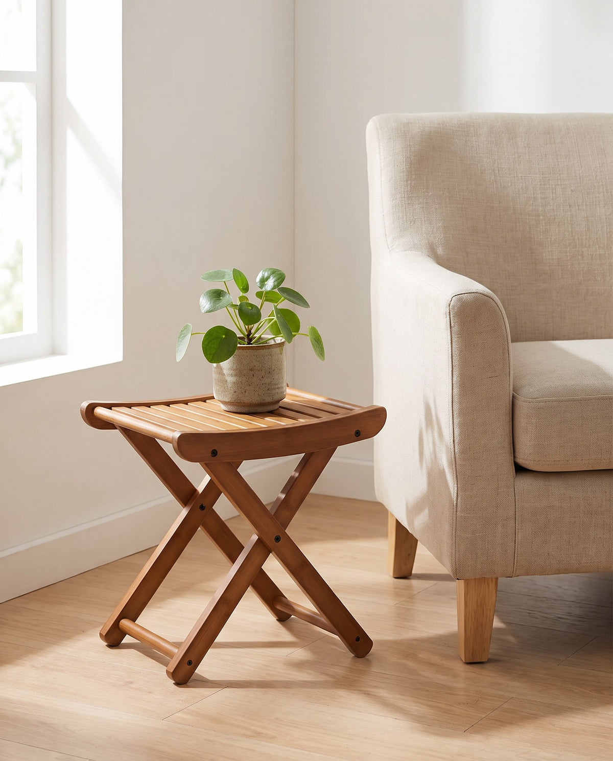 Interlaken bamboo stool used as a plant stand beside an armchair
