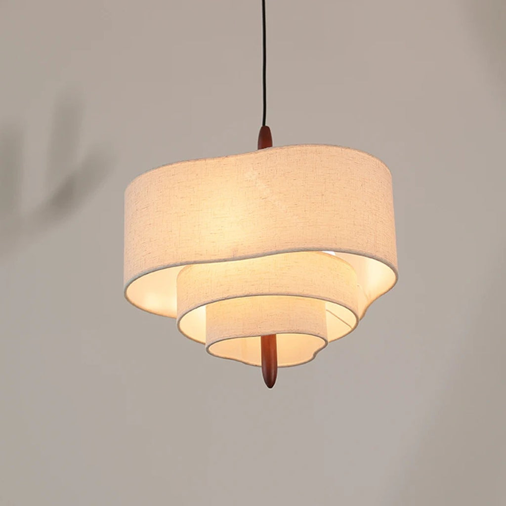 Lauenburg tiered fabric chandelier lit, product photo showing the waved tiers and wood finial