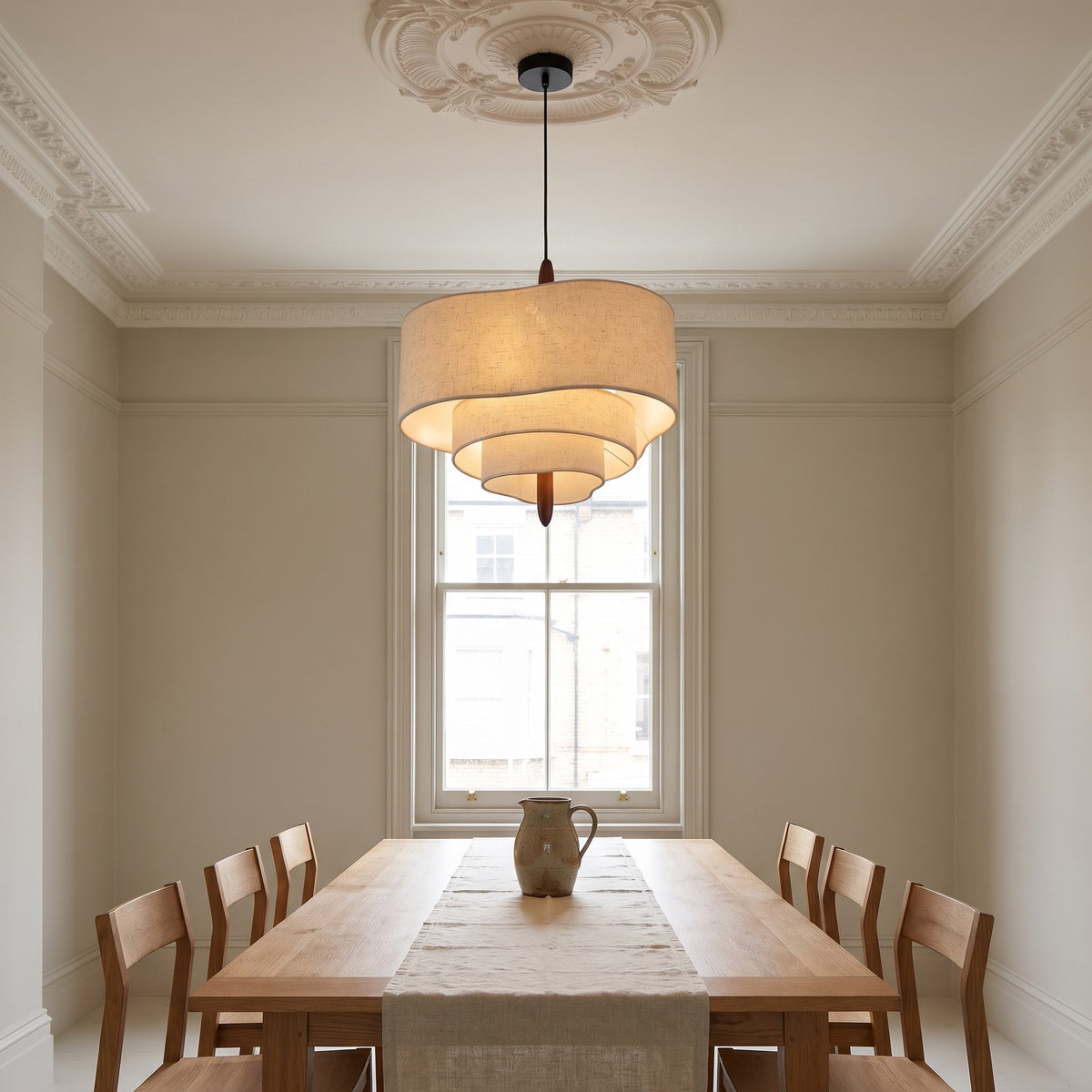 Lauenburg chandelier hanging from a ceiling rose over an oak dining table in a period dining room