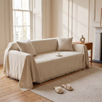 Mariefred sofa throw in Oat on a sofa in a period living room with a marble fireplace