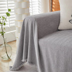 Mariefred sofa throw in Stone Grey draped over a sofa arm, product photo
