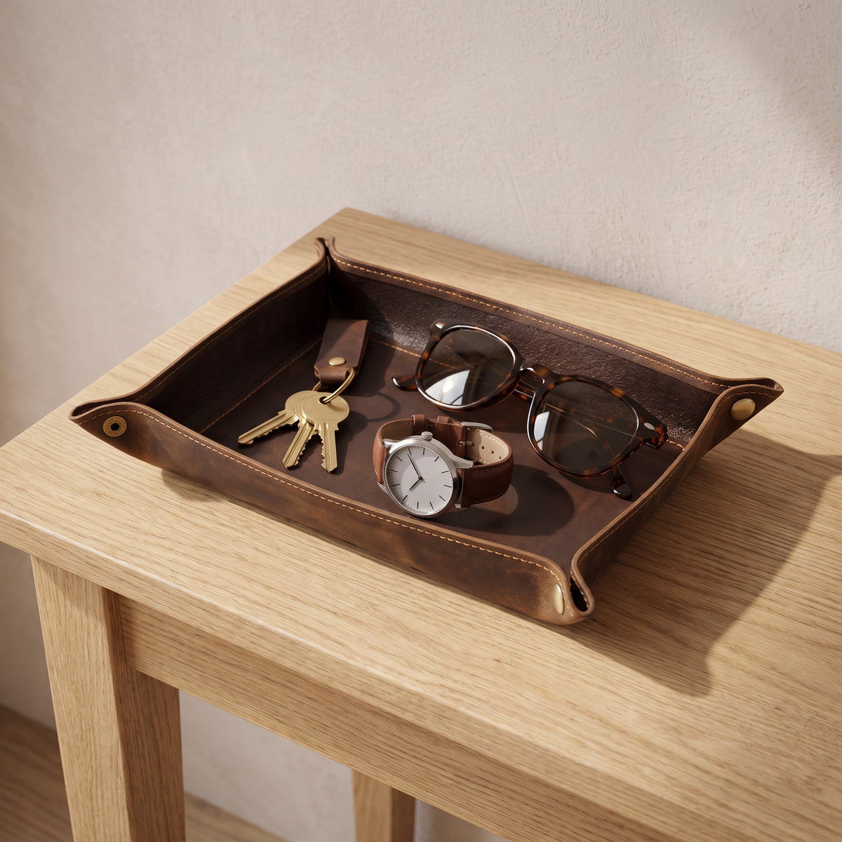 Mechelen leather valet tray on a hallway console holding keys, a watch and sunglasses