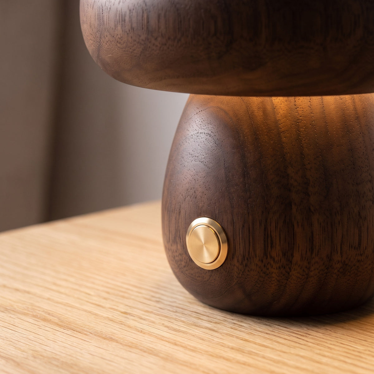Close up of the brass touch button and walnut grain on the Molln lamp