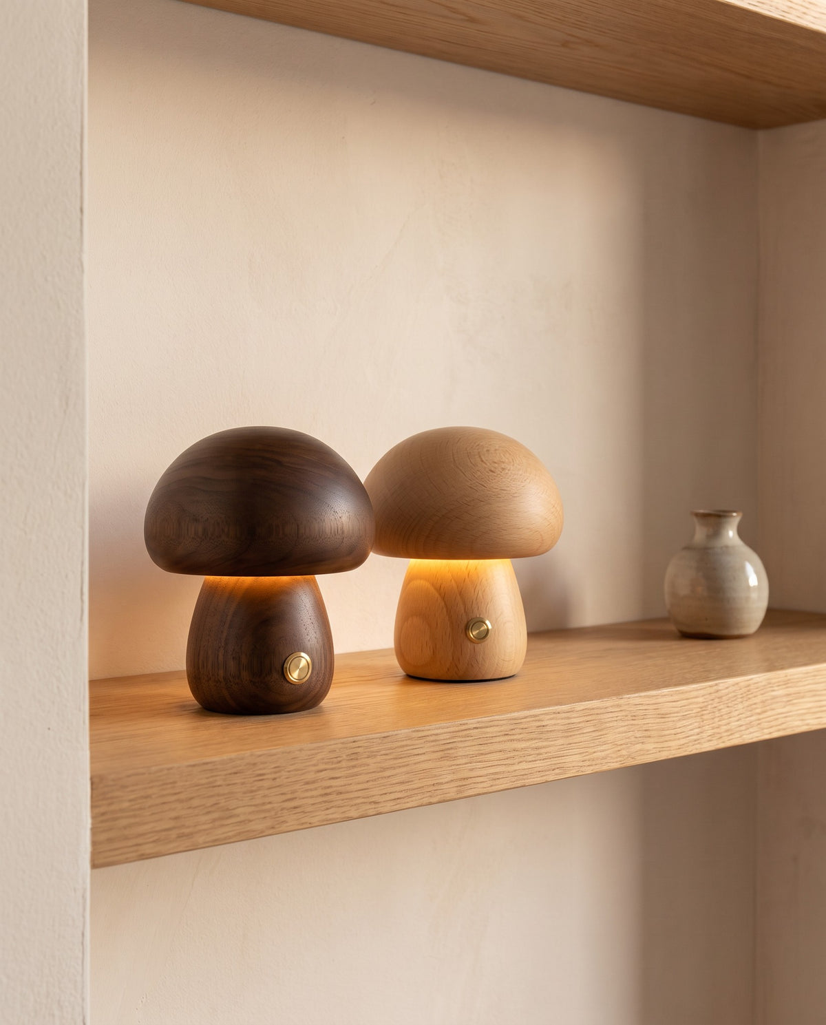Walnut and beech Molln mushroom lamps glowing side by side on a shelf