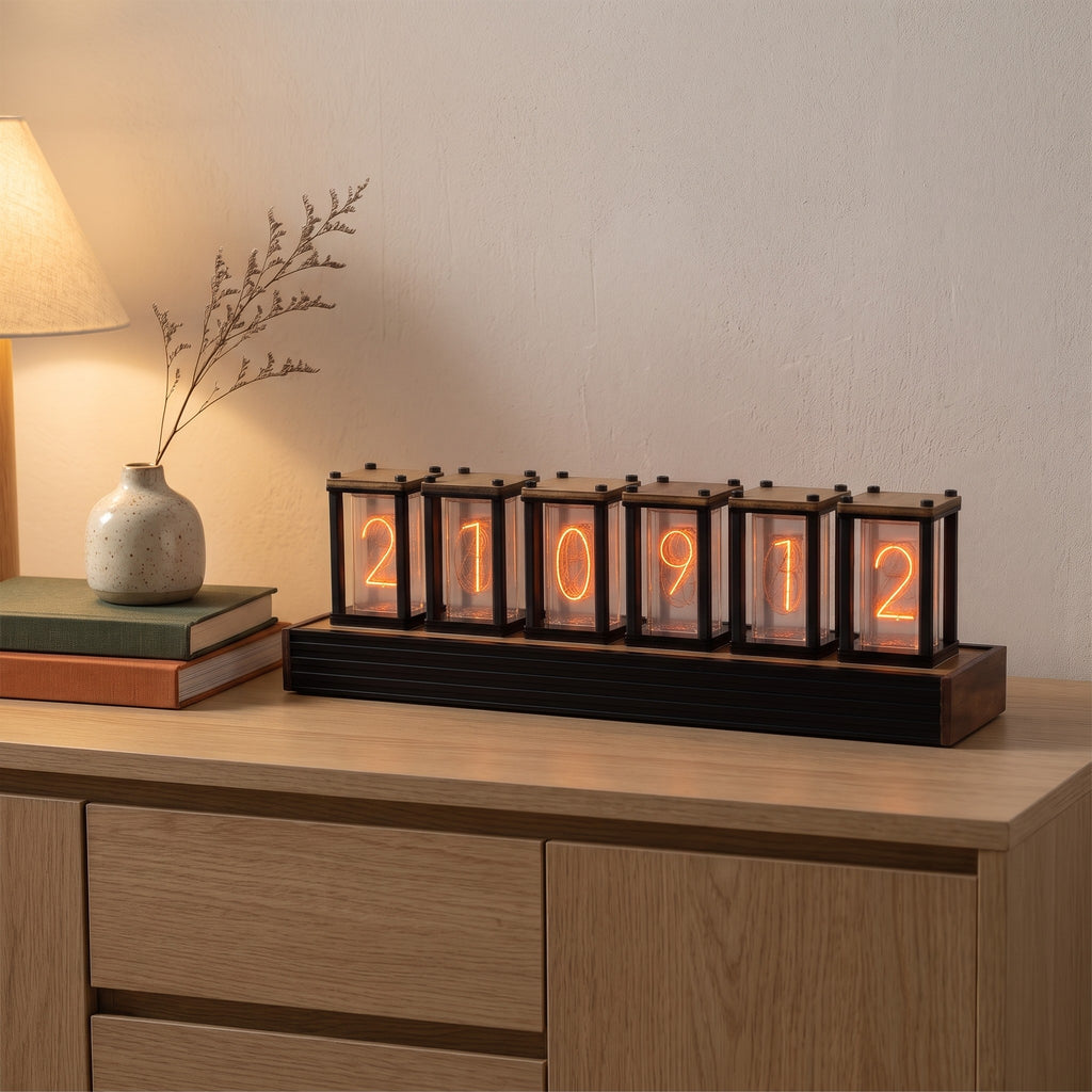 Pforzheim nixie style clock on an oak sideboard beside books and a vase