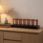 Pforzheim nixie style clock on an oak sideboard beside books and a vase