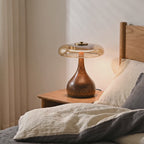 Amber glass table lamp glowing on a bedside table