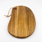 Rinteln organic acacia serving board with hanging cord on a white background