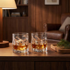 Two Sandhamn whisky glasses with whisky and ice on a walnut sideboard