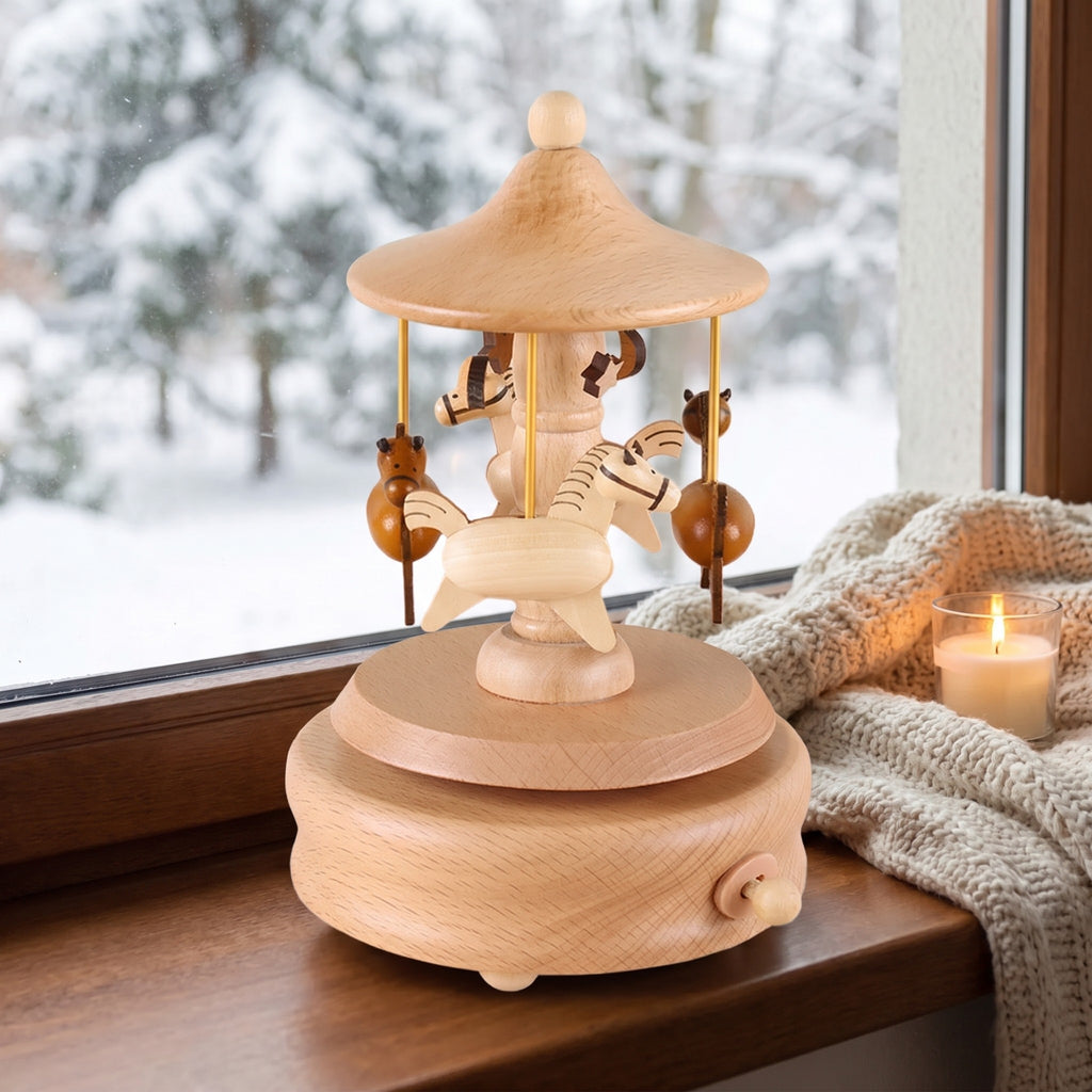 Seiffen wooden carousel music box on a winter window sill beside a candle