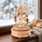 Seiffen wooden carousel music box on a winter window sill beside a candle