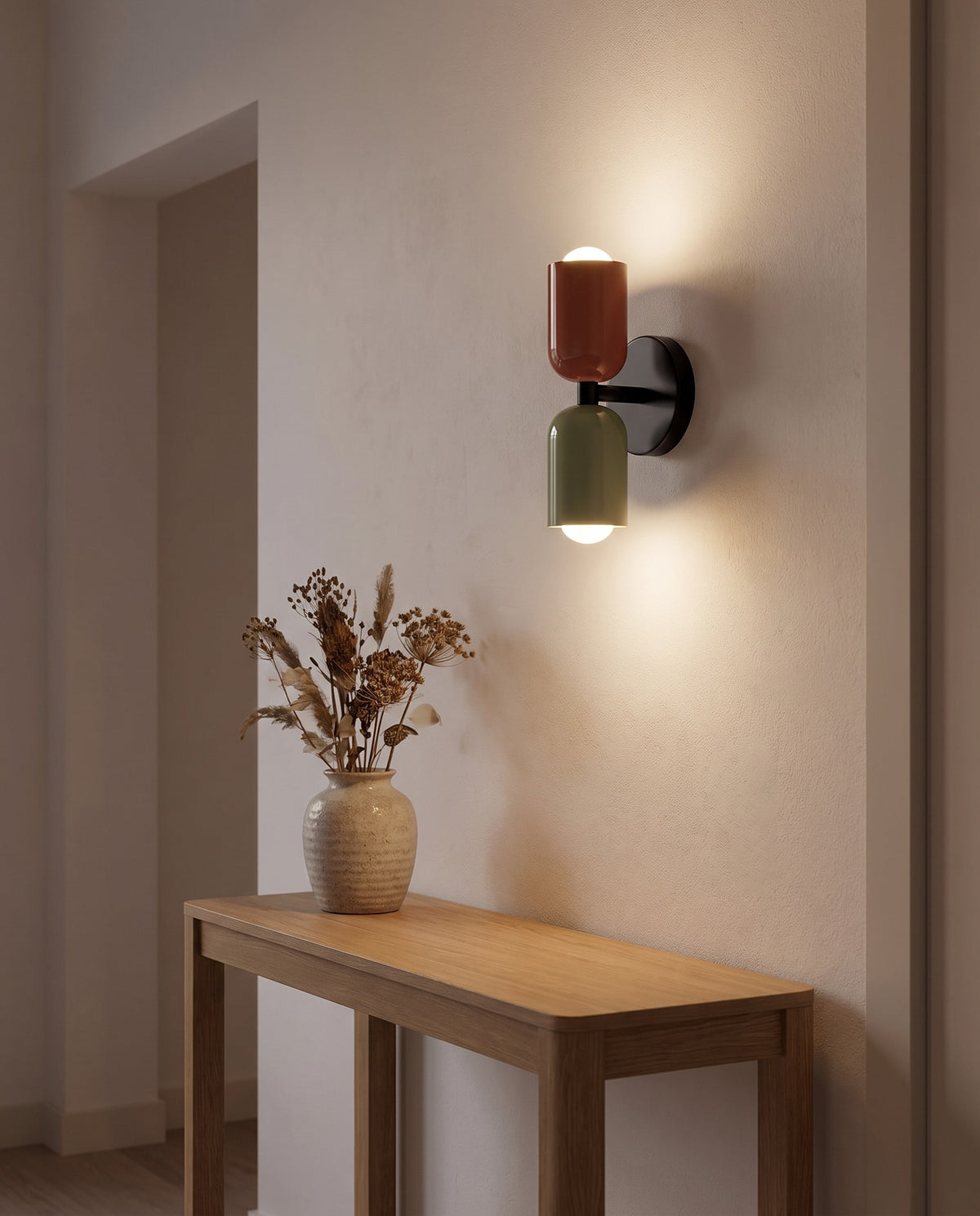Thun rust and sage wall light on a black plate above a hallway console