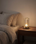 Zermatt gold lantern lamp glowing on a walnut bedside table